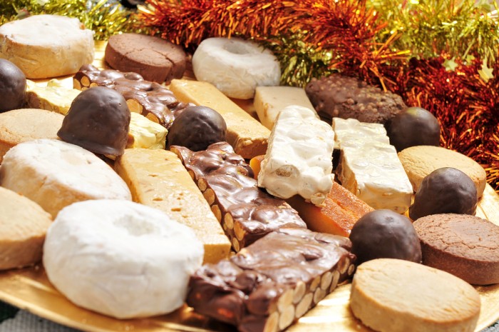 closeup of a golden tray with different turron, mantecados and polvorones, typical christmas confections in Spain