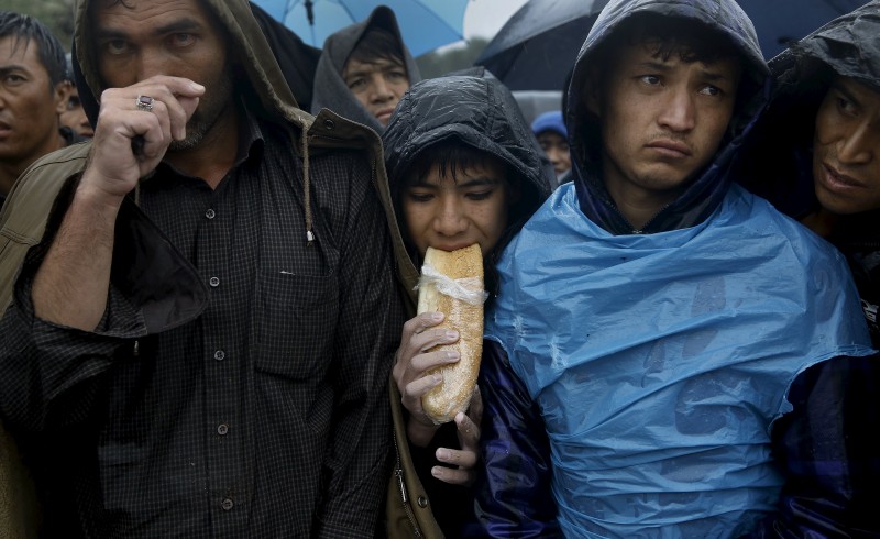 Afghan migrants line-up while waiting to be registered at a camp during a rainstorm on the Greek island of Lesbos October 23, 2015. Over half a million refugees and migrants have arrived by sea in Greece this year and the rate of arrivals is rising, in a rush to beat the onset of freezing winter, the United Nations said. REUTERS/Yannis Behrakis