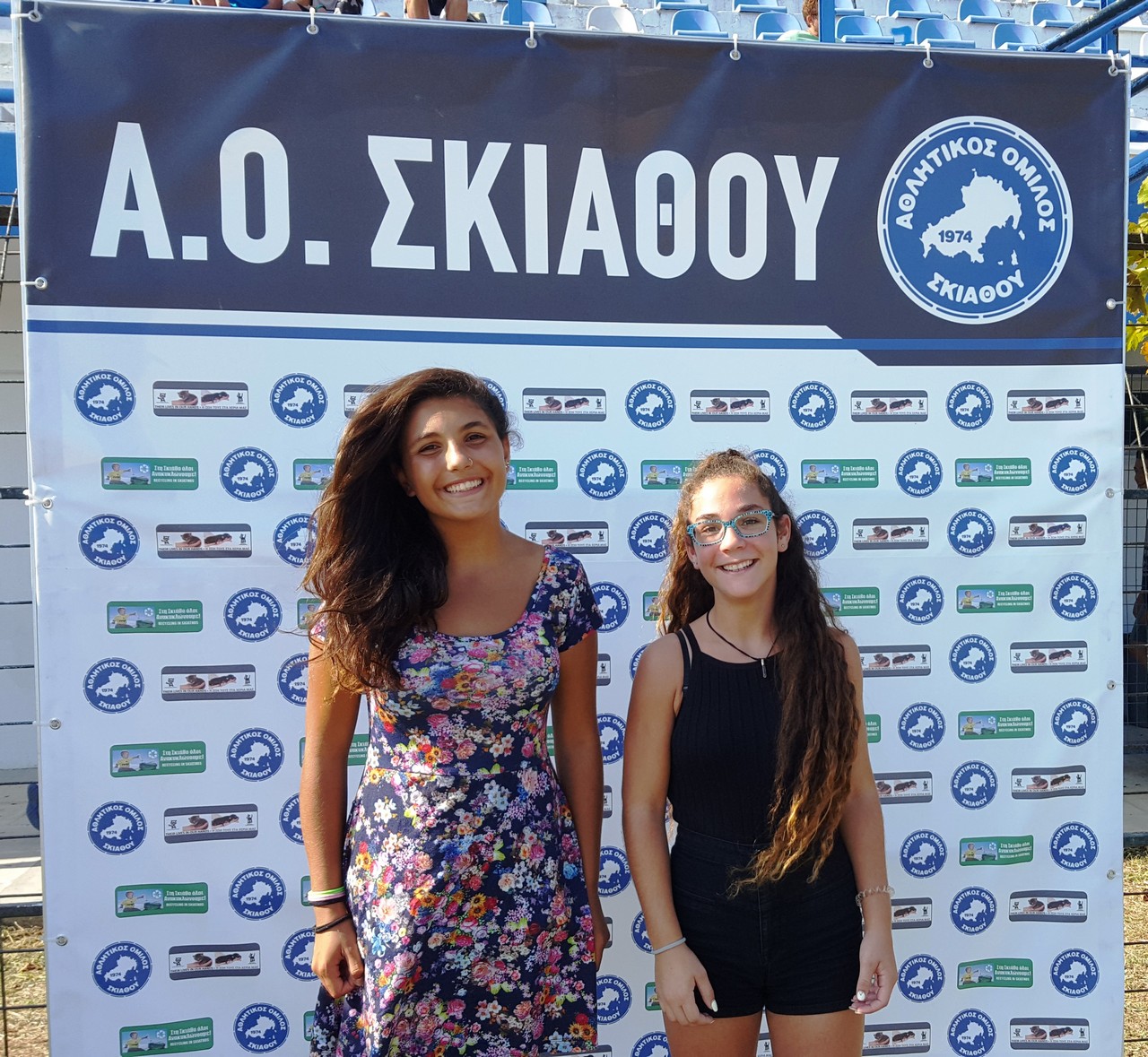 Δύο κορίτσια από την ομάδα ποδοσφαίρου του ΑΟ Σκιάθου φωτογραφίζονται στο banner της αγαπημενης τους ομάδας